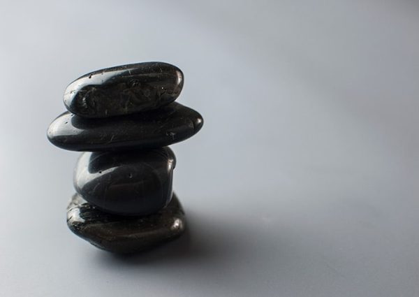 Functional Therapeutics Swfl - A stack of black stones on a gray background.